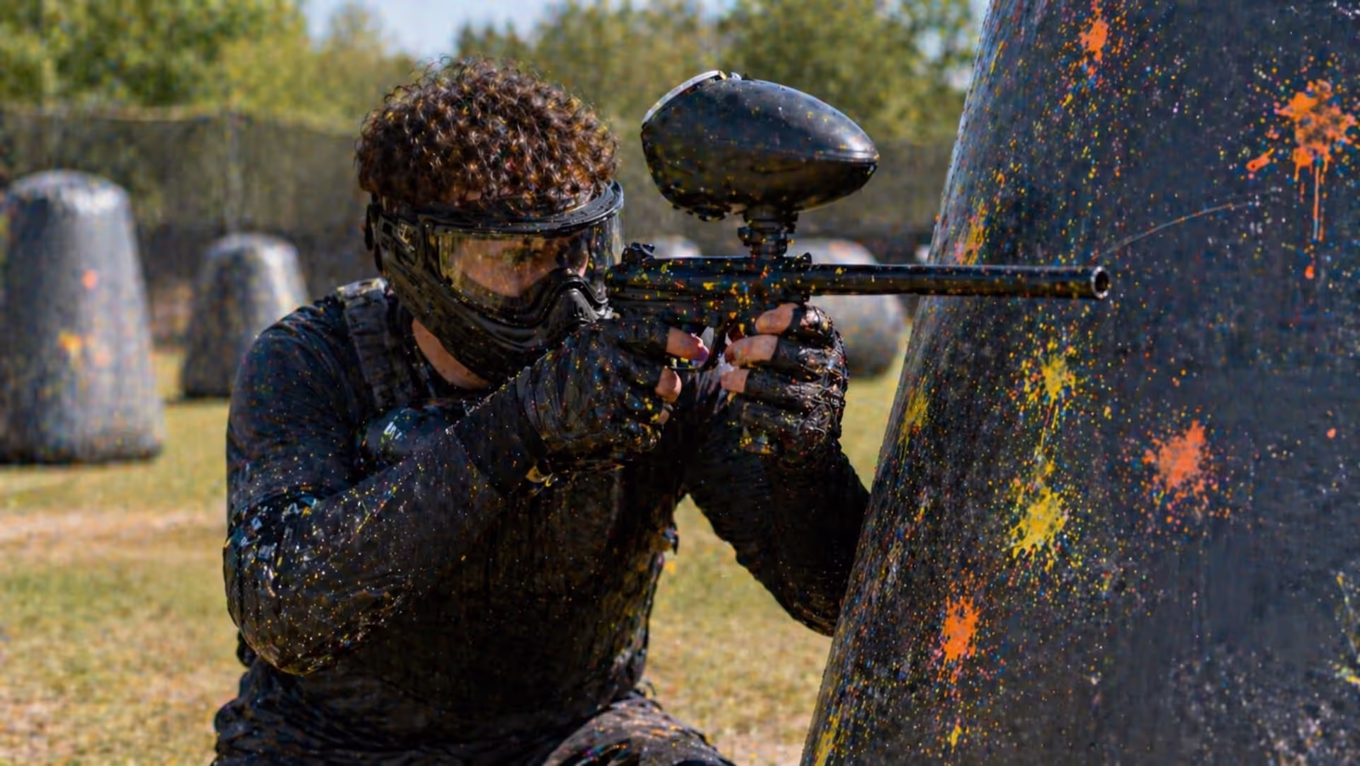 paintball player holding marker ready to shoot on field
