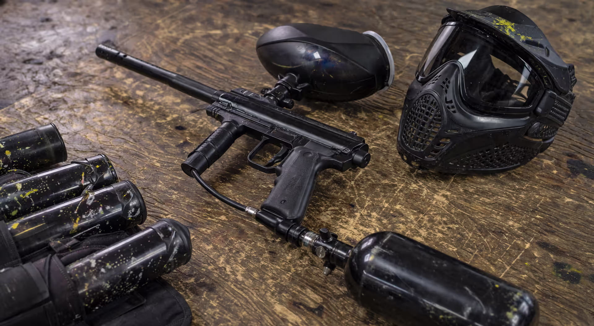 paintball marker with CO2 tank attached on table with gear